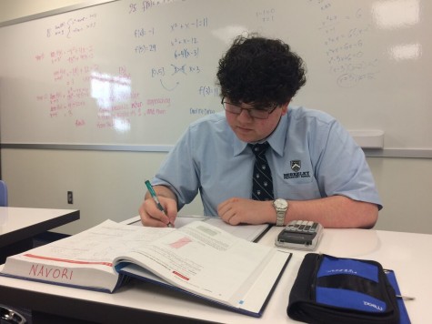 Junior Alec Navori uses his time wisely as he completes his AP Calculus homework. 