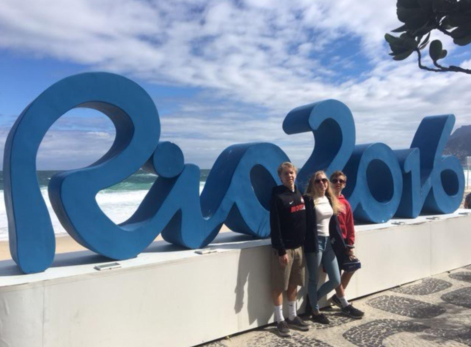 CHEERING ON TEAM USA: Wade Munger '18, Sarah Munger '19 and Caleb Munger '21 (from left) stand in front of the Rio 2016 sign in Rio, Brazil where the 2016 Summer Olympics took place. The Mungers supported Team USA in the stands as various teams won gold throughout the games. Munger stated, "Although many different countries were there cheering on their teams, there definitely was a sense of national pride for Team USA at every event."