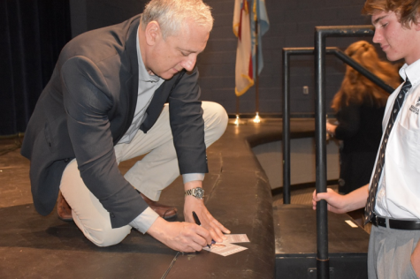 SIGN HERE PLEASE: Before the presentation, students line up to get Massimino’s signature. Many students were impressed by Massimino and his engineering accomplishments on the Hubble Space Telescope. 