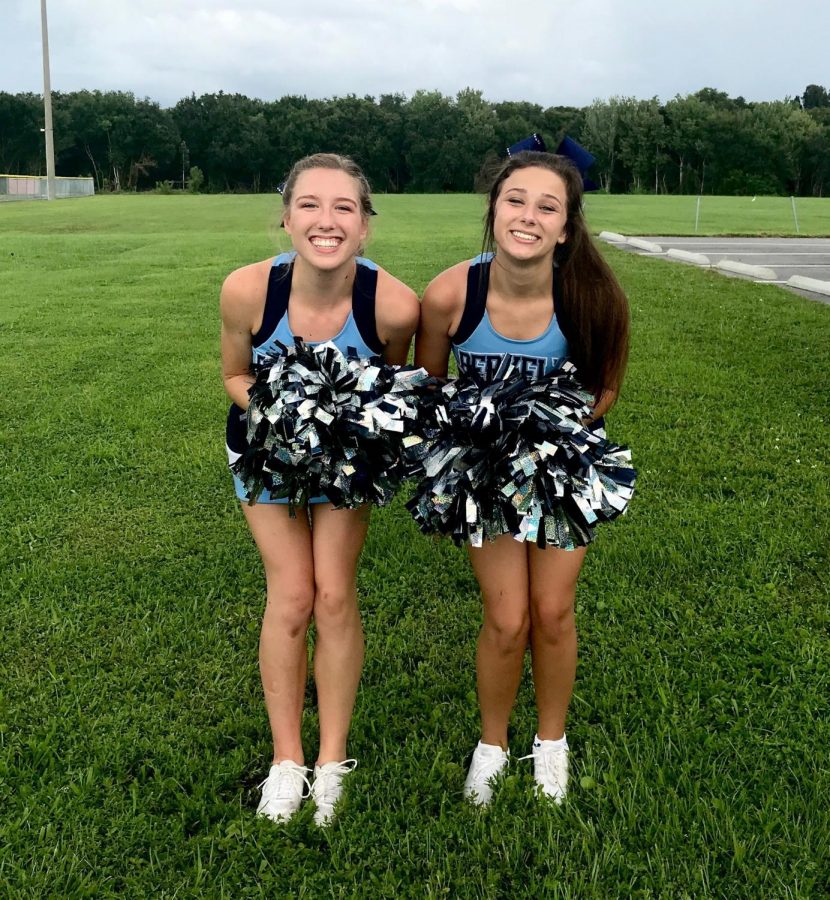 RAIN OR SHINE: Tess Fuller ’20 and Sofia Livingstone ’20 pose in a grassy area adjacent to the football field before the Friday night football game.