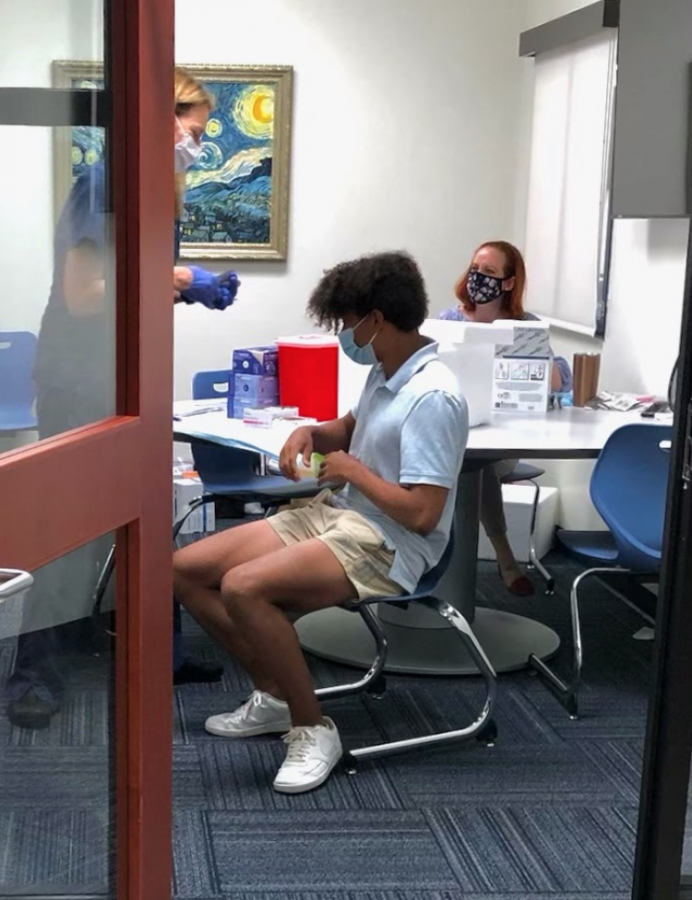 CALLING THE SHOTS: Sam Adebonojo 23 recieves his first shot of the Pfizer-BioNTech vaccine at the Gries Center.