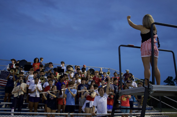 IT’S TIME TO GET HYPED: Emma Rivera ’27 directs the band playing in the bleachers. (Photo Credit: Lydia Gaurkee ’29)